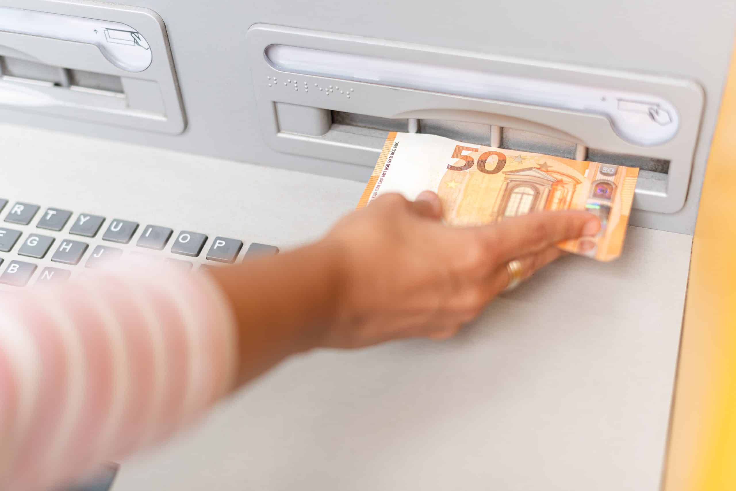 crop woman putting money on card in atm