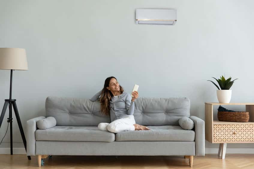 femme avec une télécommande de clim dans la main